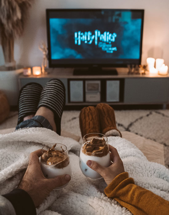 A couple snuggled up watching televison supplied by ScandiBox IPTV in Spain